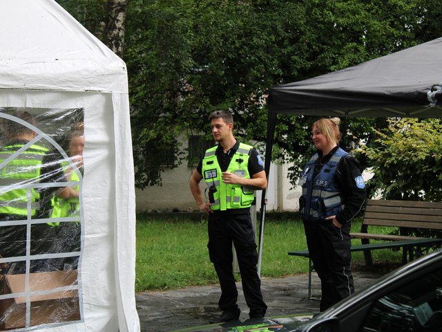 Zwei Sicherheitsmitarbeiter stehen unter einem Pavillon und tauschen sich aus beim Seehasenfest 2024 in Friedrichshafen.