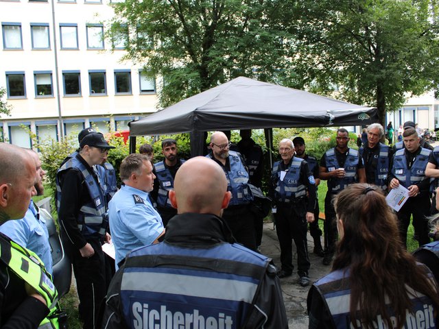 Sicherheitsleiter spricht mit seinem Team während des Seehasenfests 2024 in Friedrichshafen unter einem Pavillon.