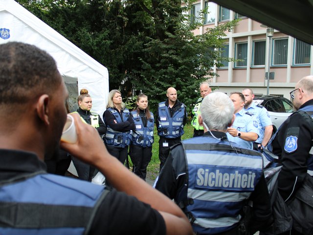 Sicherheitskräfte hören einem Briefing zu und bereiten sich auf den Einsatz beim Seehasenfest 2024 in Friedrichshafen vor.